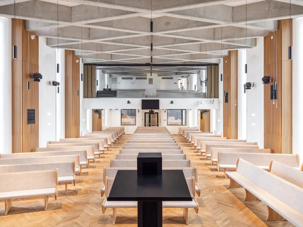 The main hall of Labirint Church, with a white beamed ceiling and wooden pews